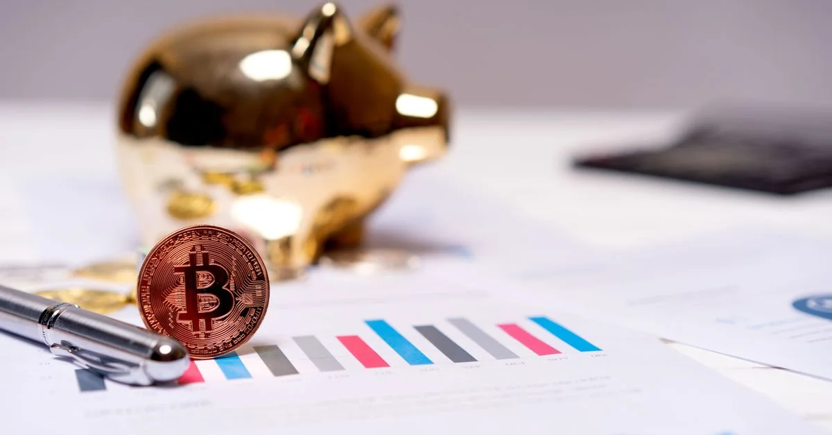 Une pièce de Bitcoin sur des graphiques financiers avec une tirelire en or, symbolisant la finance moderne.